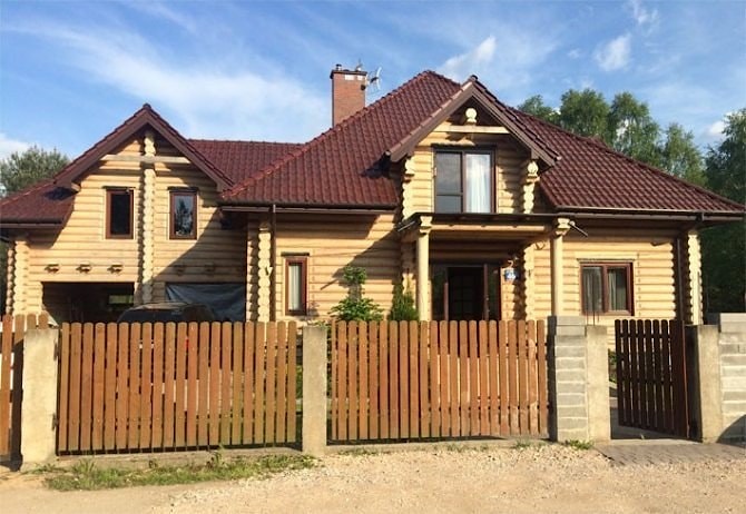 Costruzione della casa in legno a un piano con un soppalco fatta di tronchi, con tetto di tegole, chiavi in mano. Foto - Varsavia, Polonia