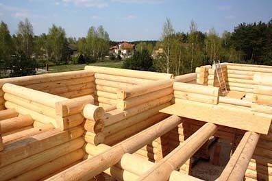 Costruzione della casa in legno a un piano con un soppalco fatta di tronchi, con tetto di tegole, chiavi in mano. Foto - Varsavia, Polonia
