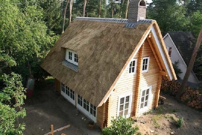 Costruzione di case di legno di tronchi, con un tetto di paglia, l'immagine costruzione "chiavi in mano" -Olanda, l'Europa   